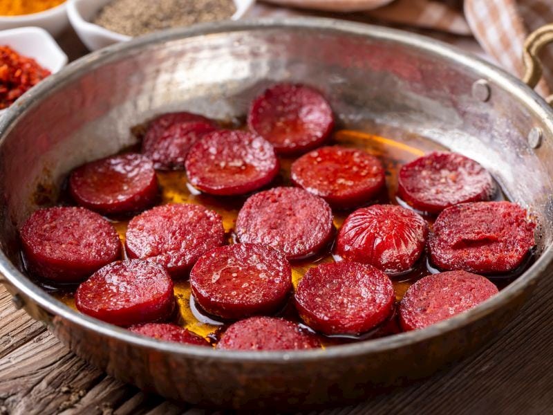 Kızarmış sucuk dilimleri bir tavada, lezzetli Anadolu sofrasının geleneksel Türk yemekleri arasında yer alır.